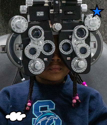 Girl looking through ophthalmoscope to test her vision