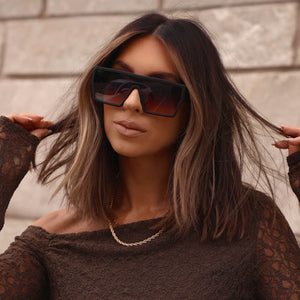 on model - female wearing diff eyewear featuring the electra shield sunglasses with a matte black frame and twilight purple to pink gradient lenses front view