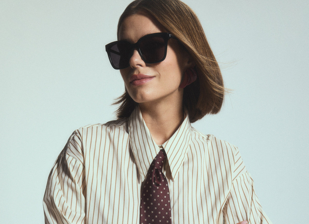 Studio shot of working professional woman wearing Bella black sunglasses
