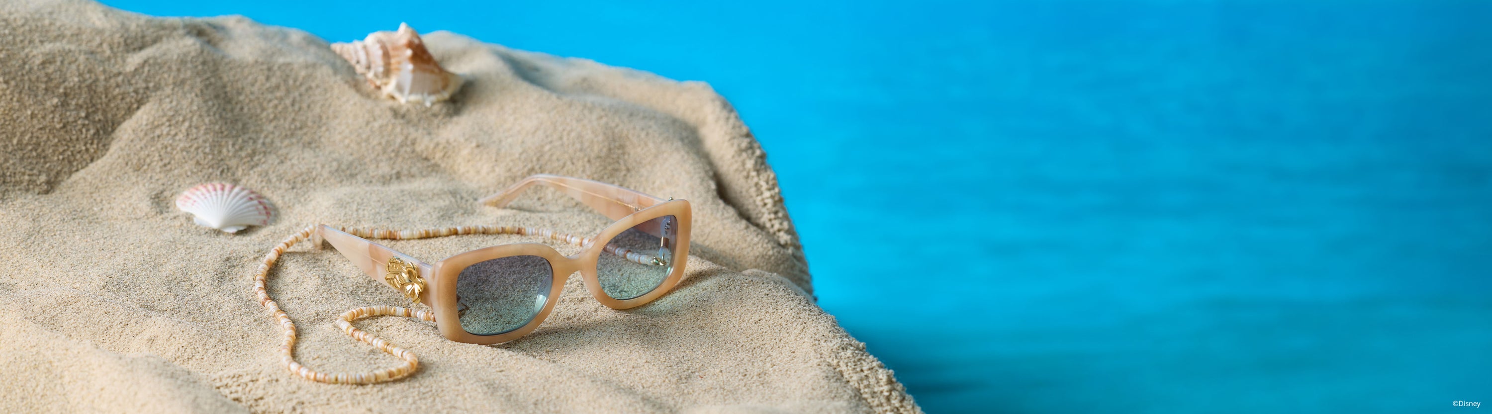 disney princess moana tinted sunglasses on sand with seashells