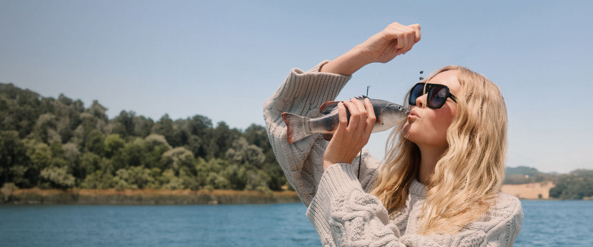 Blonde woman in grey cardigan lakeside cabin fashion