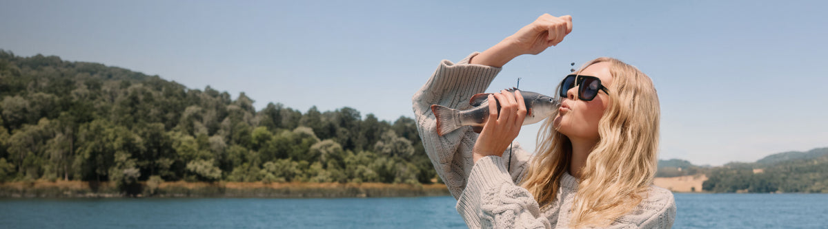 Blonde woman in grey cardigan lakeside cabin fashion