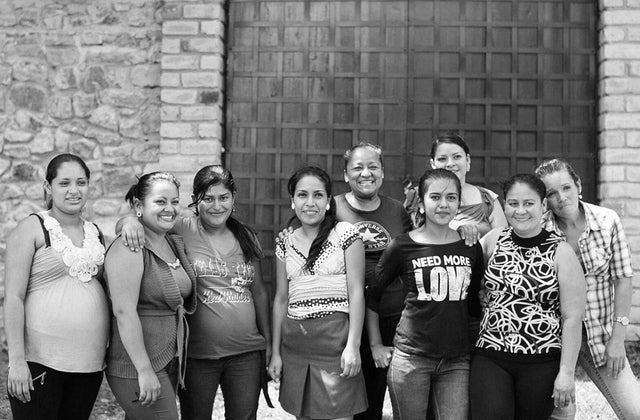 Group of female artisans from Tribe Alive posing in front of stone building