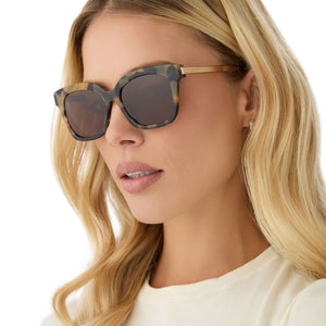 on model - female wearing diff eyewear featuring the bella xs square sunglasses with a brown kombu frame and brown polarized lenses side view