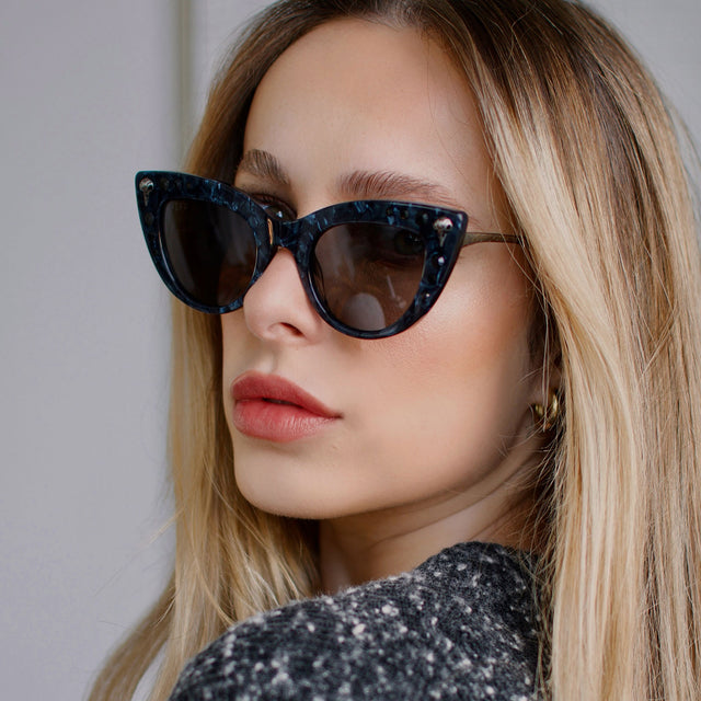 customer content - larissa.montana wearing harry potter x diff eyewear bellatrix cat eye sunglasses with a geo black frame and solid grey lenses front view