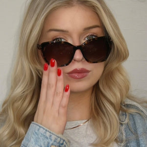 lifestyle - claricerocchi wearing diff eyewear featuring the vera cateye sunglasses with a espresso tortoise frame and brown gradient polarized lenses front view
