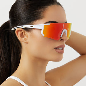 on model - female wearing diff sport heat shield sunglasses with a matte white frame and sunset mirror polarized lenses angled view