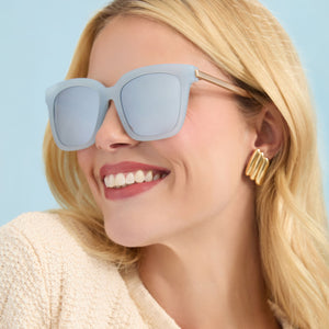 on model - female wearing diff eyewear featuring the bella square sunglasses with a blue dust frame and blue gradient flash lenses angled view