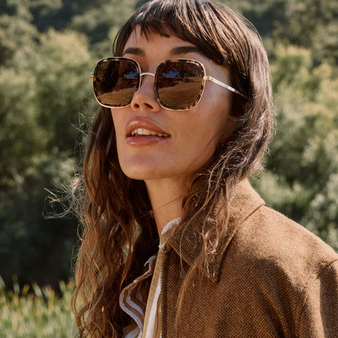 life style - female walking outdoors wearing diff eyewear josie square sunglasses with a espresso tortoise frame and brown polarized lenses front view