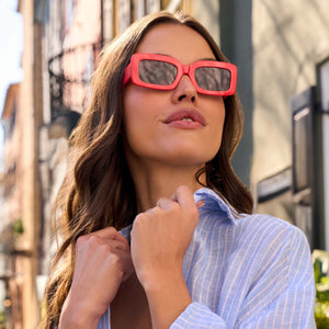 on model - female wearing diff eyewear featuring the indy rectangle sunglasses with a sunset bright coral frame and grey lenses front view