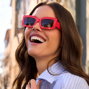 on model - female wearing diff eyewear featuring the indy rectangle sunglasses with a sunset bright coral frame and grey lenses angled view