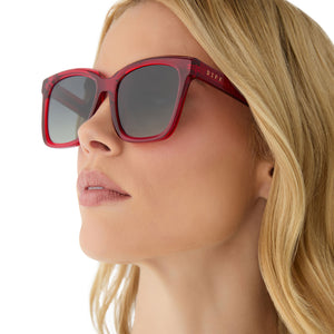 on model - female wearing diff eyewear featuring the meredith square sunglasses with a red hot summer frame and grey gradient polarized lenses angled view