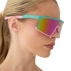 on model - female wearing diff sport featuring the spike shield sunglasses with a turquoise & hot pink frame and pink rush mirror polarized lenses side view