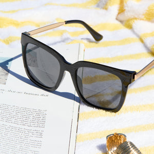 lifestyle - still life of diff eyewear hailey black grey reading sunglasses lay on a towel outdoors with a book