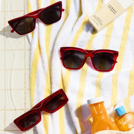 red hot summer sunglasses on top of yellow and white stripe towel