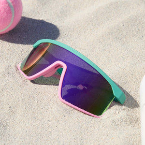 lifestyle - still life of diff sport spike sunglasses with rainbow lens laying in the sand on the beach