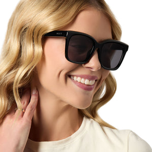 on model - female wearing diff eyewear meredith square sunglasses with a black acetate frame and grey lenses angled view
