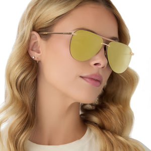 on model - female wearing diff eyewear tahoe aviator oversized sunglasses with a gold metal frame and brilliant gold mirror lenses angled view