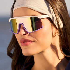 on model - female wearing diff sport featuring the spike shield sunglasses with a matte white + lavender frame and sherbert rainbow mirror polarized lenses angled view