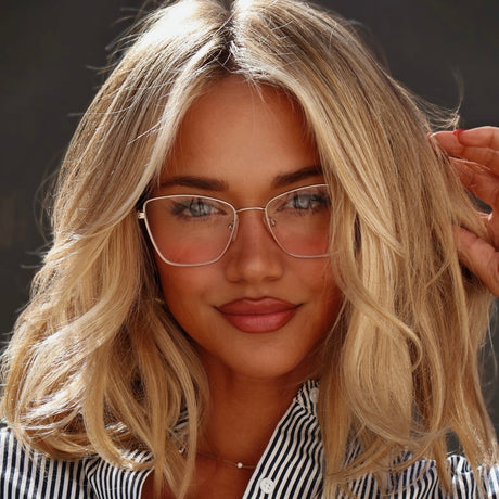 lifestyle - ashley smith blonde influencer wearing gold wire frame eyeglasses with striped button up shirt