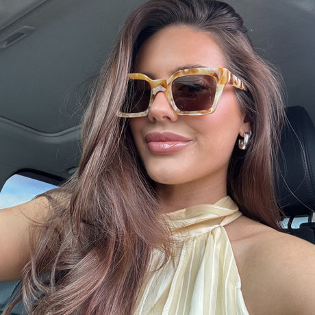 brunette wearing greer gilded tort sunglasses in car