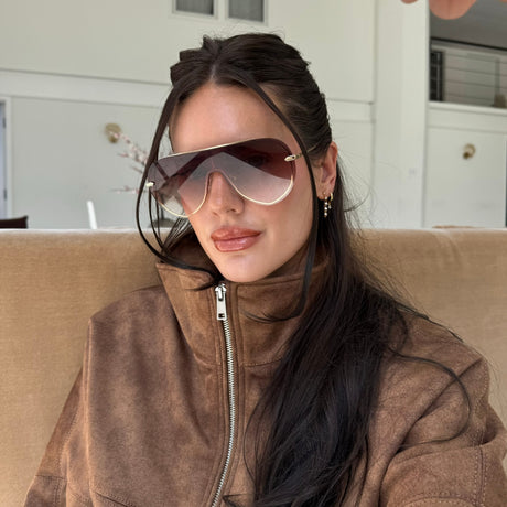 lifestyle - abigail herring brunette wearing fall fashion brown suede zip up jacket with brown tinted shielded sunglasses with metal rim