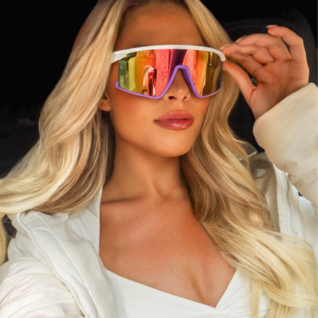 lifestyle - blonde model wearing rainbow shielded sunglasses with white puffer jacket