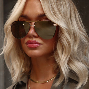 lifestyle - minimally her blonde influencer wearing gold aviator sunglasses with gold necklace