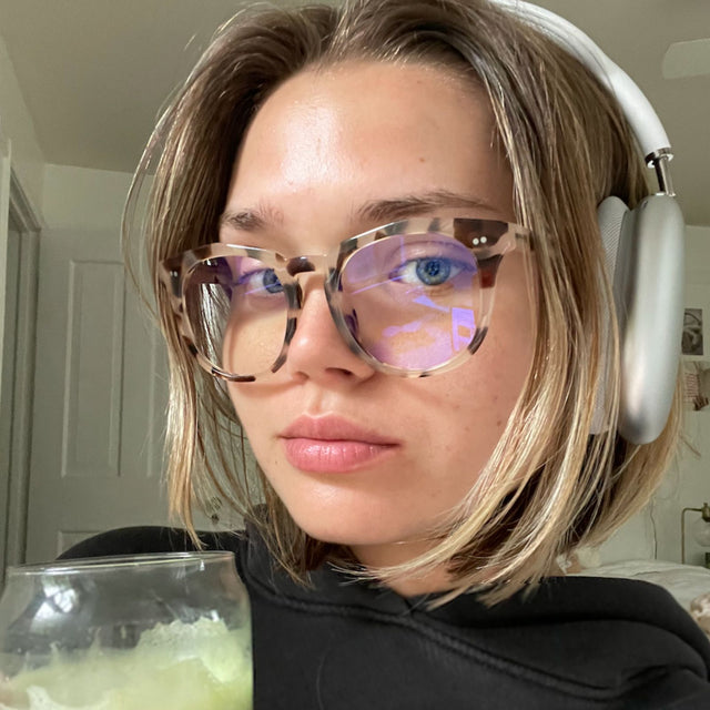 customer content - female wearing headphones and cream tort blue light glasses