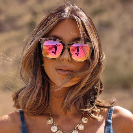 brunette wearing  bella cream tort pink mirror sunglasses in a desert