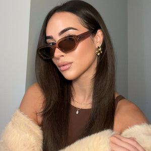 lifestyle - brunette model wearing brown low profile sunglasses with brown shirt and fall fashion