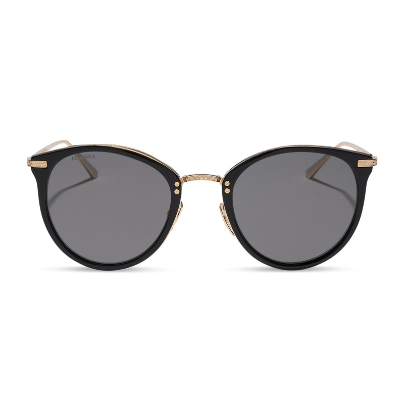 iconica featuring the hana round sunglasses with a black and gold frame and grey polarized lenses front view