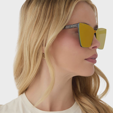 on model - video of female wearing diff eyewear featuring the goldie cat eye sunglasses with a animal frame and red hot summer mirror lenses
