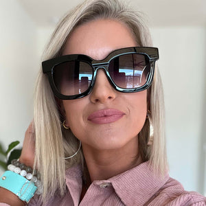 lifestyle - blonde female wearing makay sunglasses with a black frame and grey gradient sharp lenses