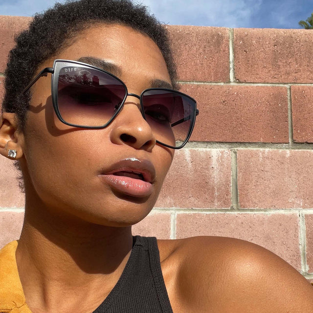 customer content - female wearing diff eyewear grace cat eye sunglasses with a matte black frame and grey gradient sharp lenses