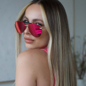 lifestyle - blonde female wearing diff eyewear tahoe aviator sunglasses with a matte gold metal frame and sunset mirror lenses angled view