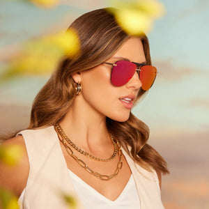 on female model wearing diff eyewear tahoe aviator sunglasses with a matte gold metal frame and sunset mirror lenses